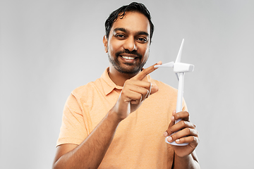 Image showing smiling young man with toy wind turbine