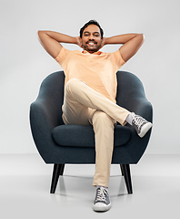 Image showing happy smiling young indian man sitting in chair