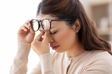 Image showing tired woman with glasses rubbing her nose bridge