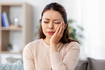 Image showing unhappy woman suffering from toothache at home