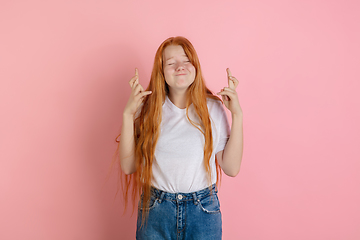 Image showing Caucasian teen girl\'s portrait isolated on coral pink studio background.