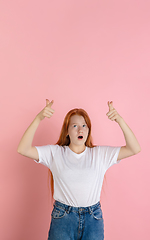 Image showing Caucasian teen girl\'s portrait isolated on coral pink studio background.