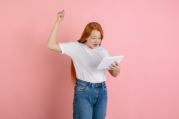 Image showing Caucasian teen girl\'s portrait isolated on coral pink studio background.