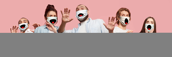 Image showing Group of frightened people, women and men wearing protective face mask on pink coral background