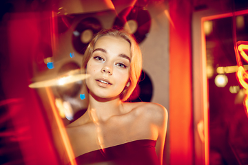 Image showing Cinematic portrait of handsome young woman in neon lighted room, stylish musician