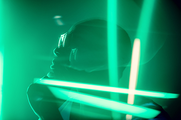 Image showing Cinematic portrait of handsome young man in neon lighted room, stylish musician