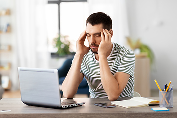 Image showing stressed man with laptop working at home office