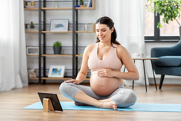 Image showing pregnant woman with tablet pc doing sports at home