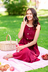 Image showing woman calling on smartphone on picnic at park