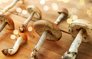 Image showing brown cap boletus mushrooms on wooden background