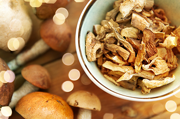 Image showing dried mushrooms in bowl on wooden background