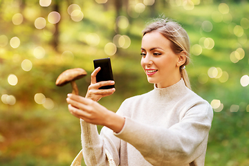 Image showing woman using smartphone to identify mushroom