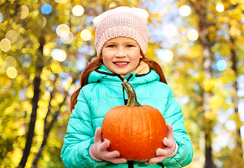 Image showing happy redhead girl with pumpkin at autumn park