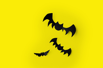 Image showing flock of black paper bats over yellow background