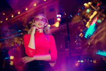 Image showing Cinematic portrait of handsome young woman in neon lighted room, stylish musician