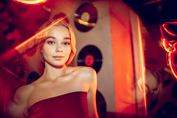 Image showing Cinematic portrait of handsome young woman in neon lighted room, stylish musician