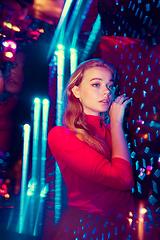 Image showing Cinematic portrait of handsome young woman in neon lighted room, stylish musician