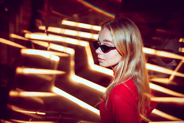 Image showing Cinematic portrait of handsome young woman in neon lighted room, stylish musician