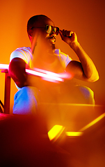 Image showing Cinematic portrait of handsome young man in neon lighted room, stylish musician