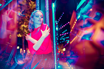 Image showing Cinematic portrait of handsome young woman in neon lighted room, stylish musician