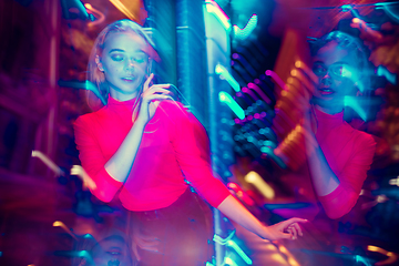 Image showing Cinematic portrait of handsome young woman in neon lighted room, stylish musician