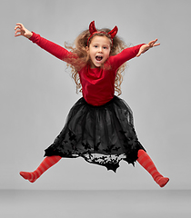 Image showing girl in halloween costume of devil jumping