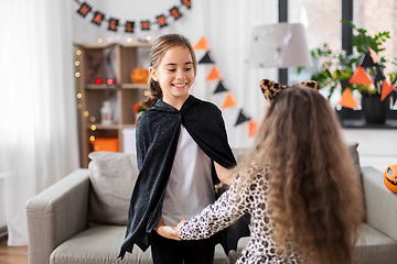 Image showing girls in halloween costumes dancing at home