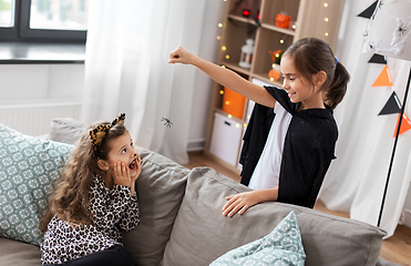 Image showing girls in halloween costumes playing with spider