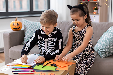 Image showing kids in halloween costumes doing crafts at home