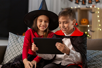 Image showing kids in halloween costumes with tablet pc at home