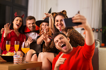 Image showing happy friends in halloween costumes taking selfie