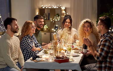 Image showing happy friends with red wine at christmas party