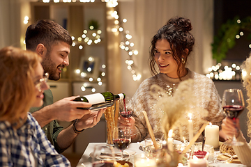 Image showing happy friends with red wine at christmas party