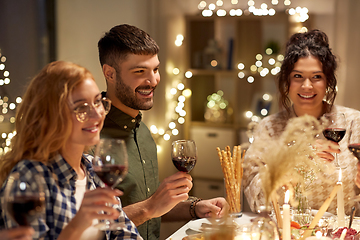 Image showing happy friends drinking red wine at christmas party