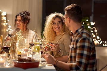 Image showing happy friends having christmas dinner at home