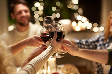 Image showing happy friends drinking red wine at christmas party