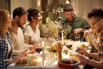 Image showing happy friends having christmas dinner at home