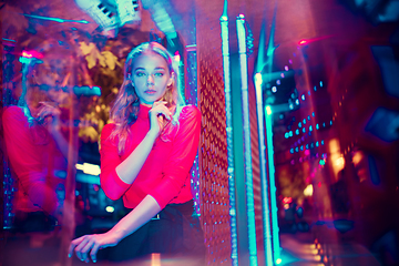 Image showing Cinematic portrait of handsome young woman in neon lighted room, stylish musician