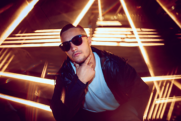 Image showing Cinematic portrait of handsome young man in neon lighted room, stylish musician