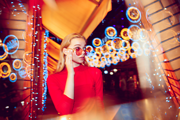 Image showing Cinematic portrait of handsome young woman in neon lighted room, stylish musician