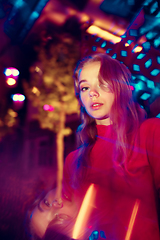 Image showing Cinematic portrait of handsome young woman in neon lighted room, stylish musician