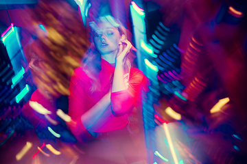 Image showing Cinematic portrait of handsome young woman in neon lighted room, stylish musician