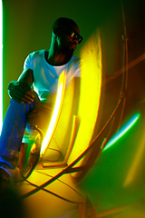 Image showing Cinematic portrait of handsome young man in neon lighted room, stylish musician