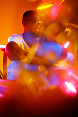 Image showing Cinematic portrait of handsome young man in neon lighted room, stylish musician