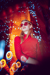 Image showing Cinematic portrait of handsome young woman in neon lighted room, stylish musician