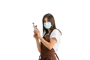 Image showing Young woman, visagiste with cosmetics isolated on white studio background