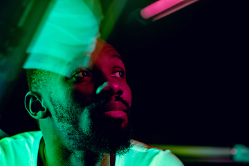 Image showing Cinematic portrait of handsome young man in neon lighted room, stylish musician