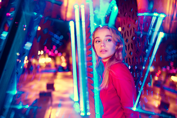 Image showing Cinematic portrait of handsome young woman in neon lighted room, stylish musician