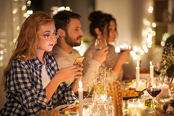 Image showing woman with smartphone at dinner party with friends