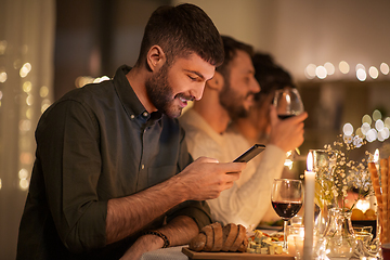 Image showing man with smartphone at dinner party with friends